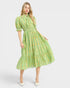 Woman wearing a green patterned dress on a white background