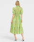Woman wearing a green dress with a floral pattern on a white background