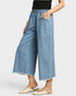 Person wearing light blue denim wide-leg pants on a white background
