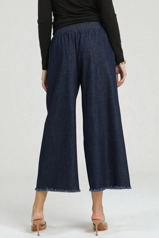 Navy wide-leg jeans worn by a person on a white background