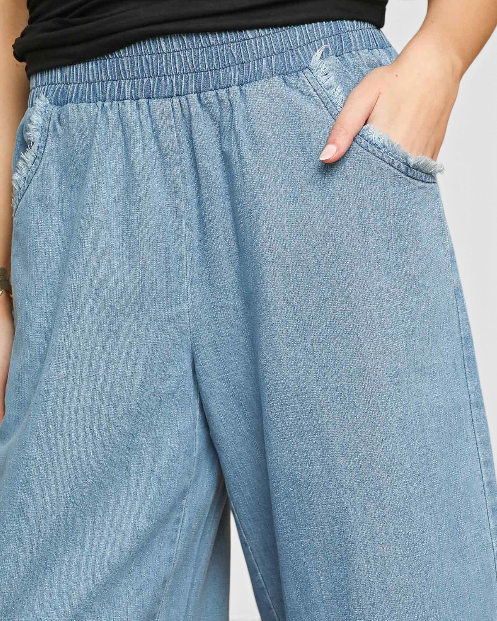 Light blue denim pants worn by a person on a plain background