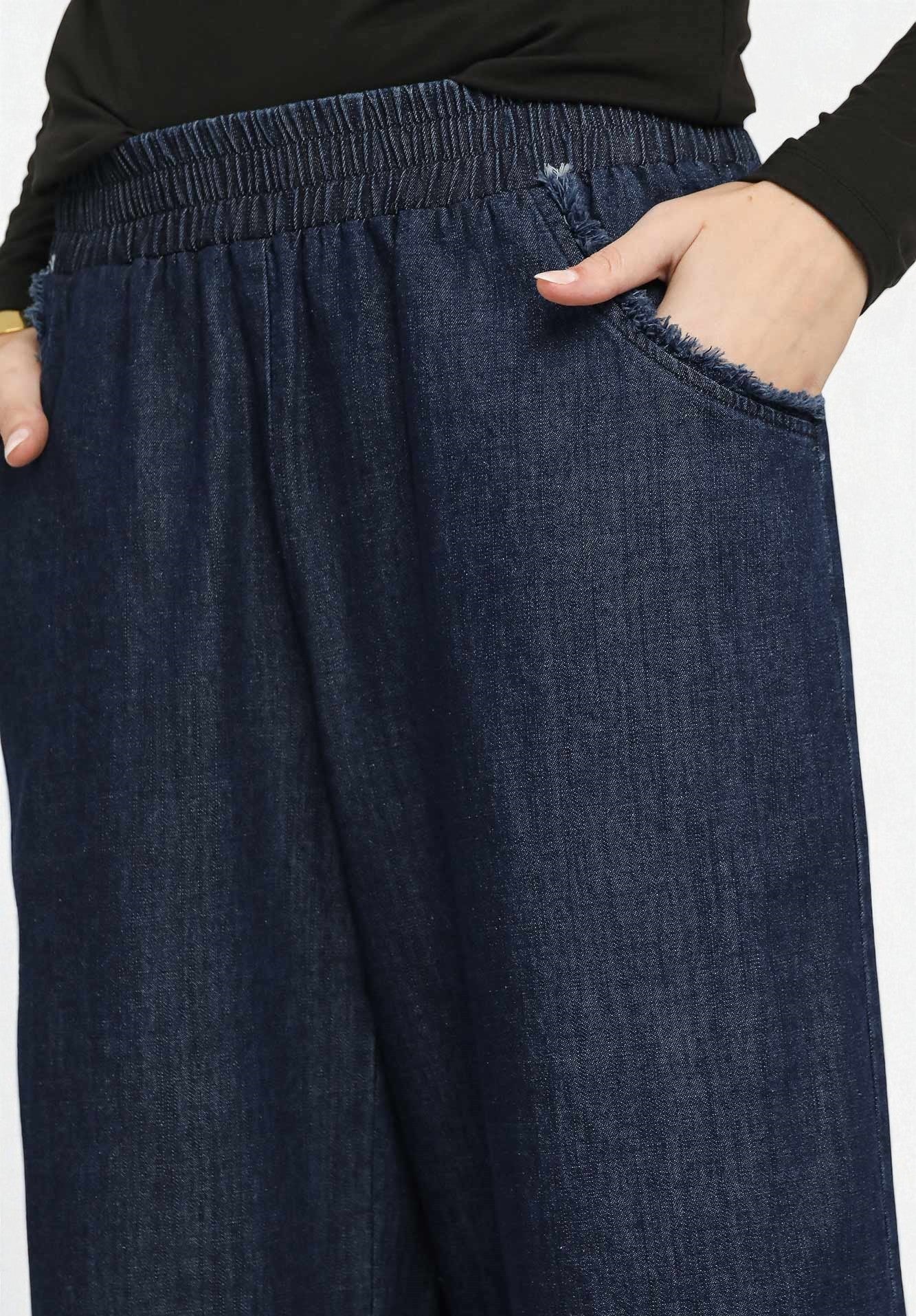 Dark blue denim pants worn by a person on a white background