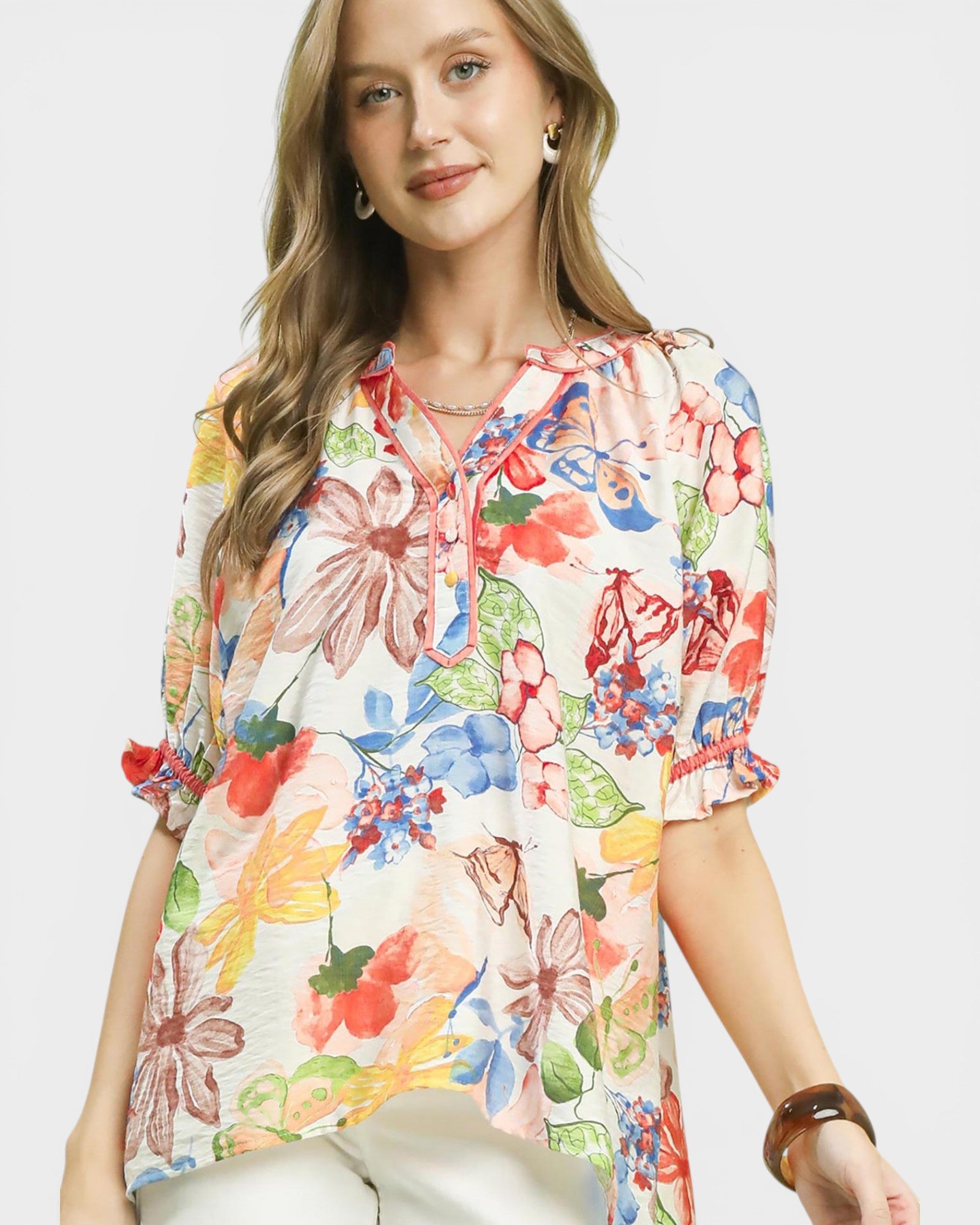 Woman wearing a colorful floral blouse on a white background