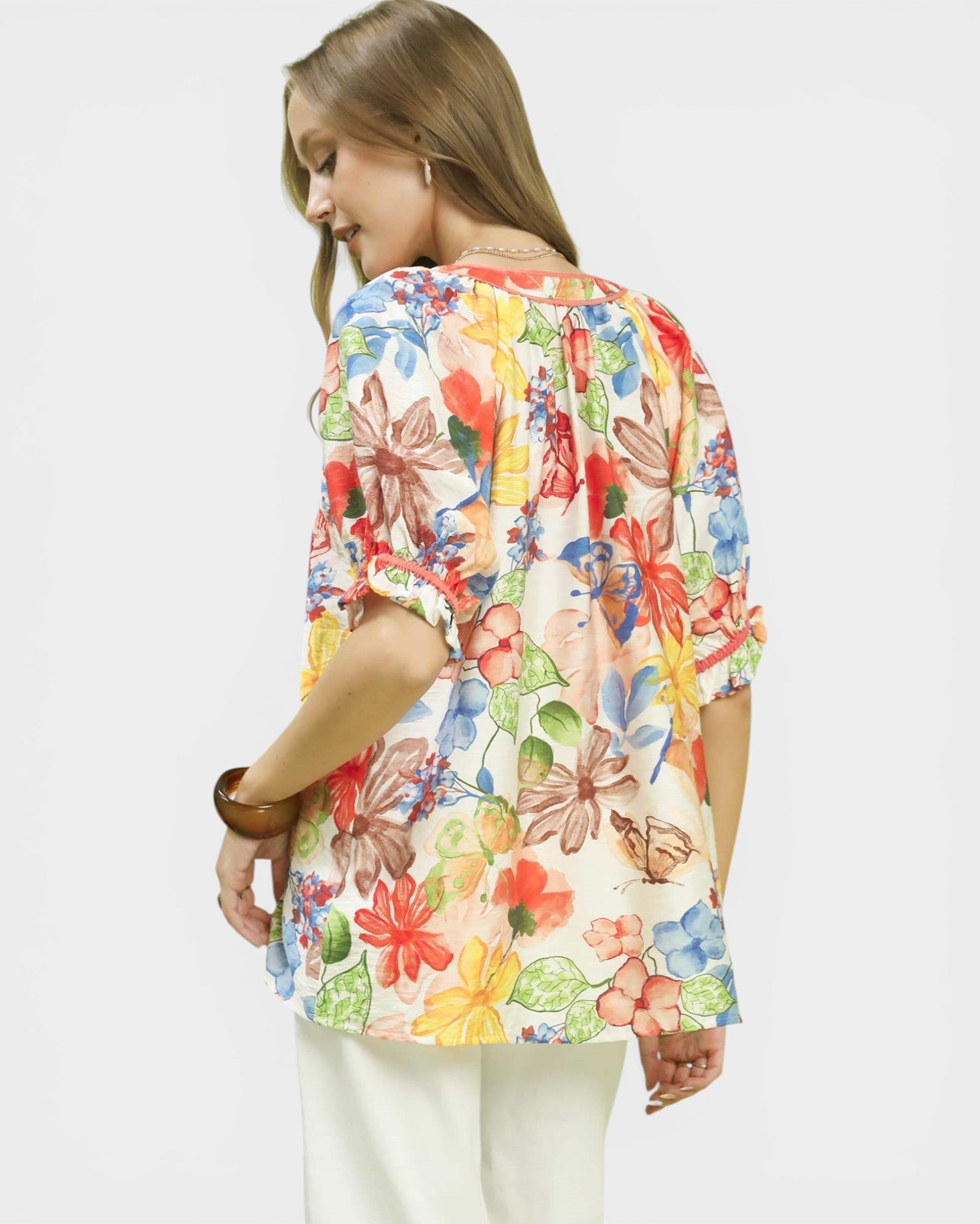 Woman wearing a colorful floral blouse on a white background