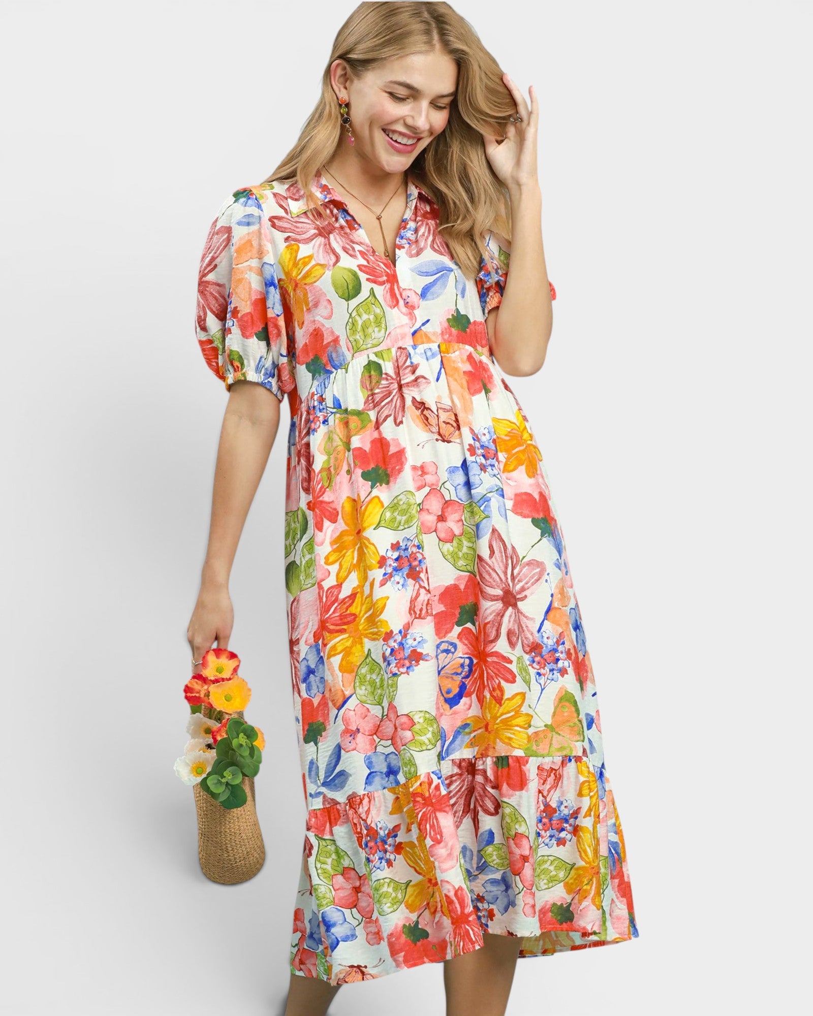 Woman wearing a colorful floral dress against a white background
