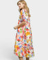 Woman wearing a colorful floral dress on a white background