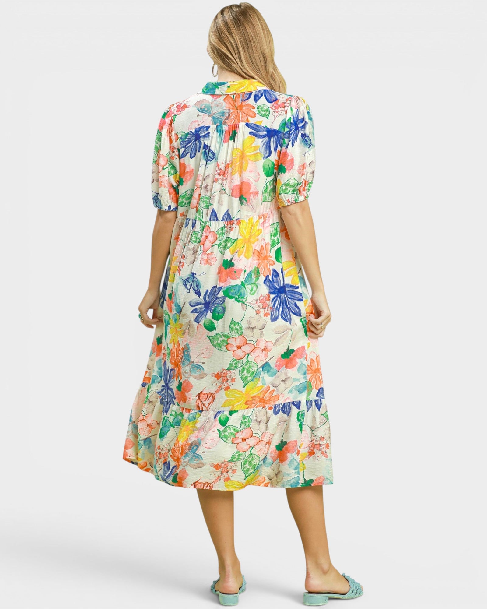 Woman wearing a colorful floral dress on a white background