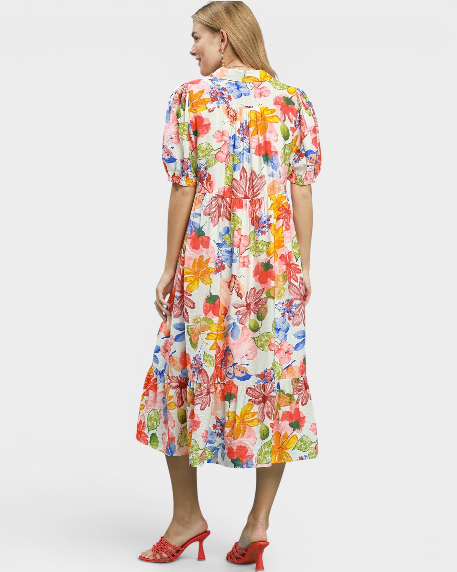 Woman wearing a colorful floral dress on a white background