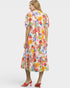 Woman wearing a colorful floral dress on a white background