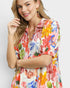 Woman wearing a colorful floral dress on a white background