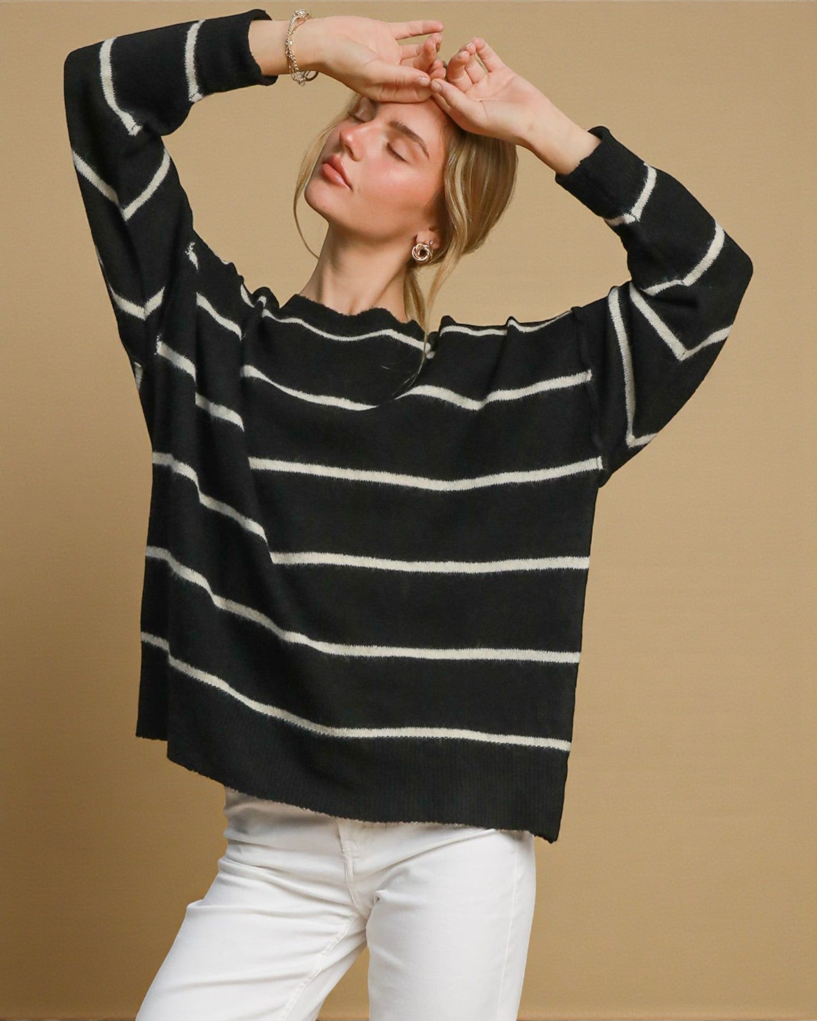 Woman wearing a black and white striped sweater against a beige background