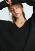 Woman wearing a black sweater against a light background
