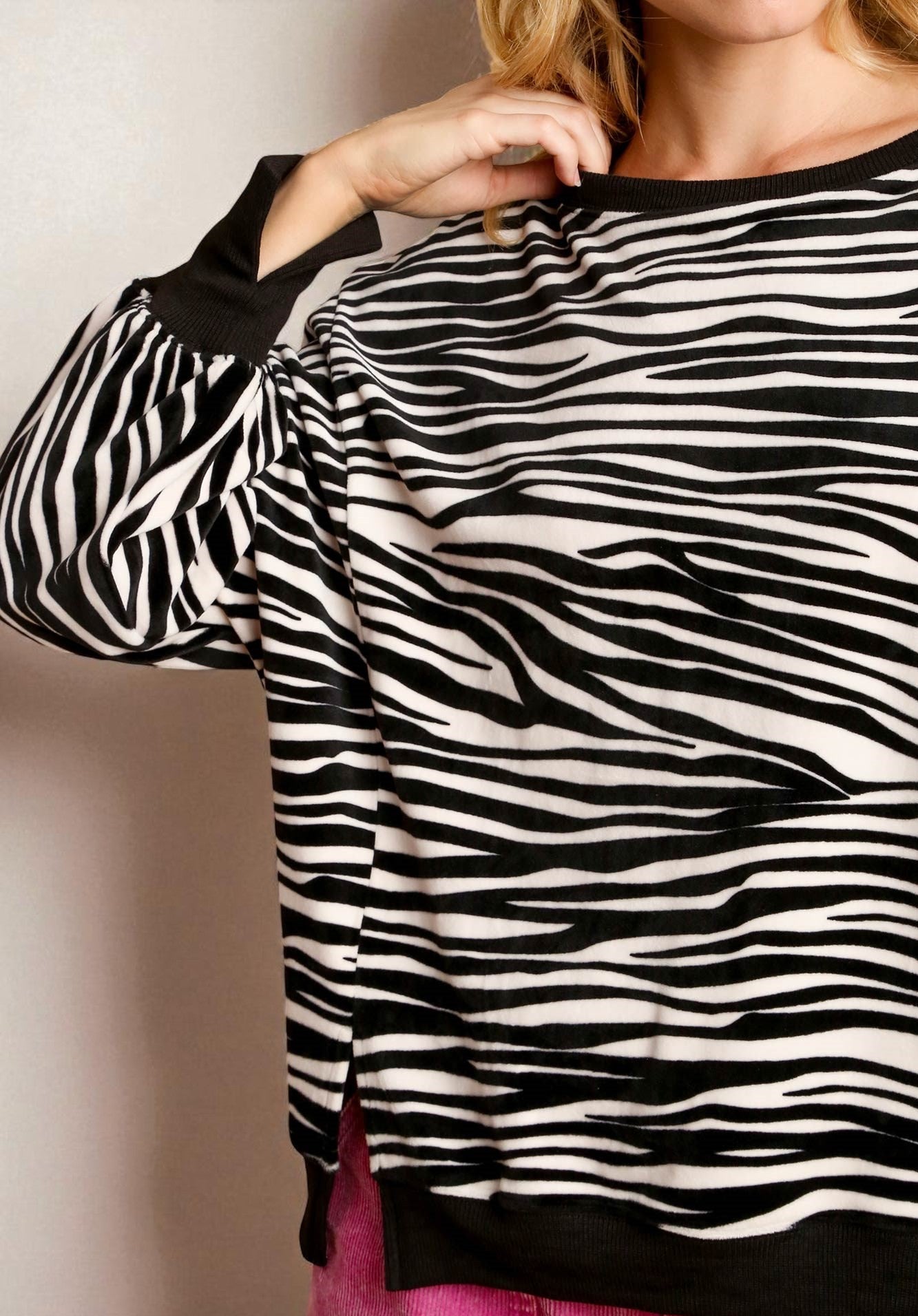 Person wearing a zebra patterned top with a plain background