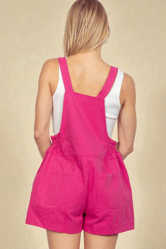 Person wearing a pink romper with white top on a beige background