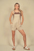 Woman wearing beige overalls with brown straps on a beige background