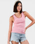 Woman wearing a pink tank top and denim shorts on a white background