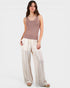 Woman wearing a sleeveless top and wide-leg pants on a white background