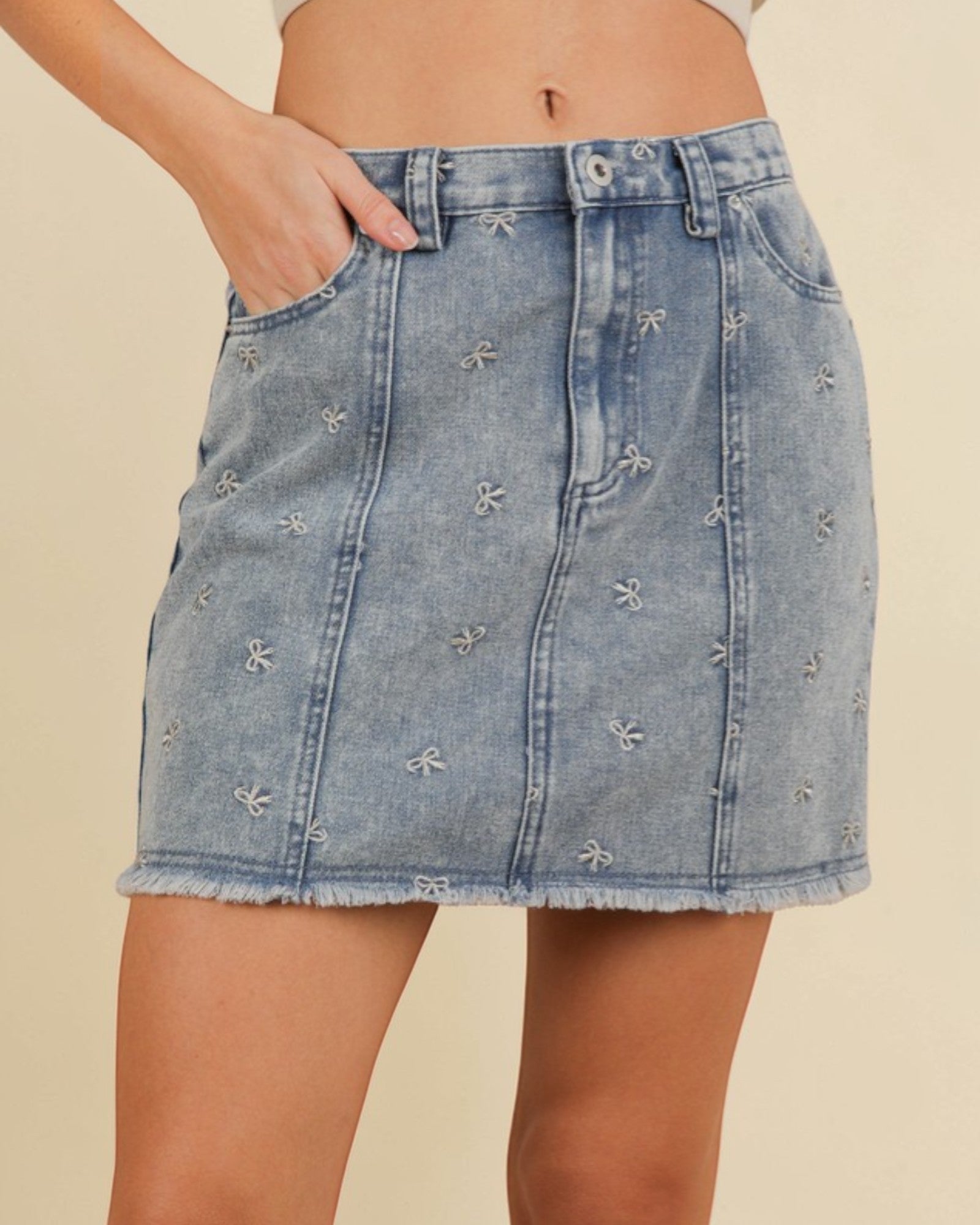 Denim skirt with floral embroidery on a beige background