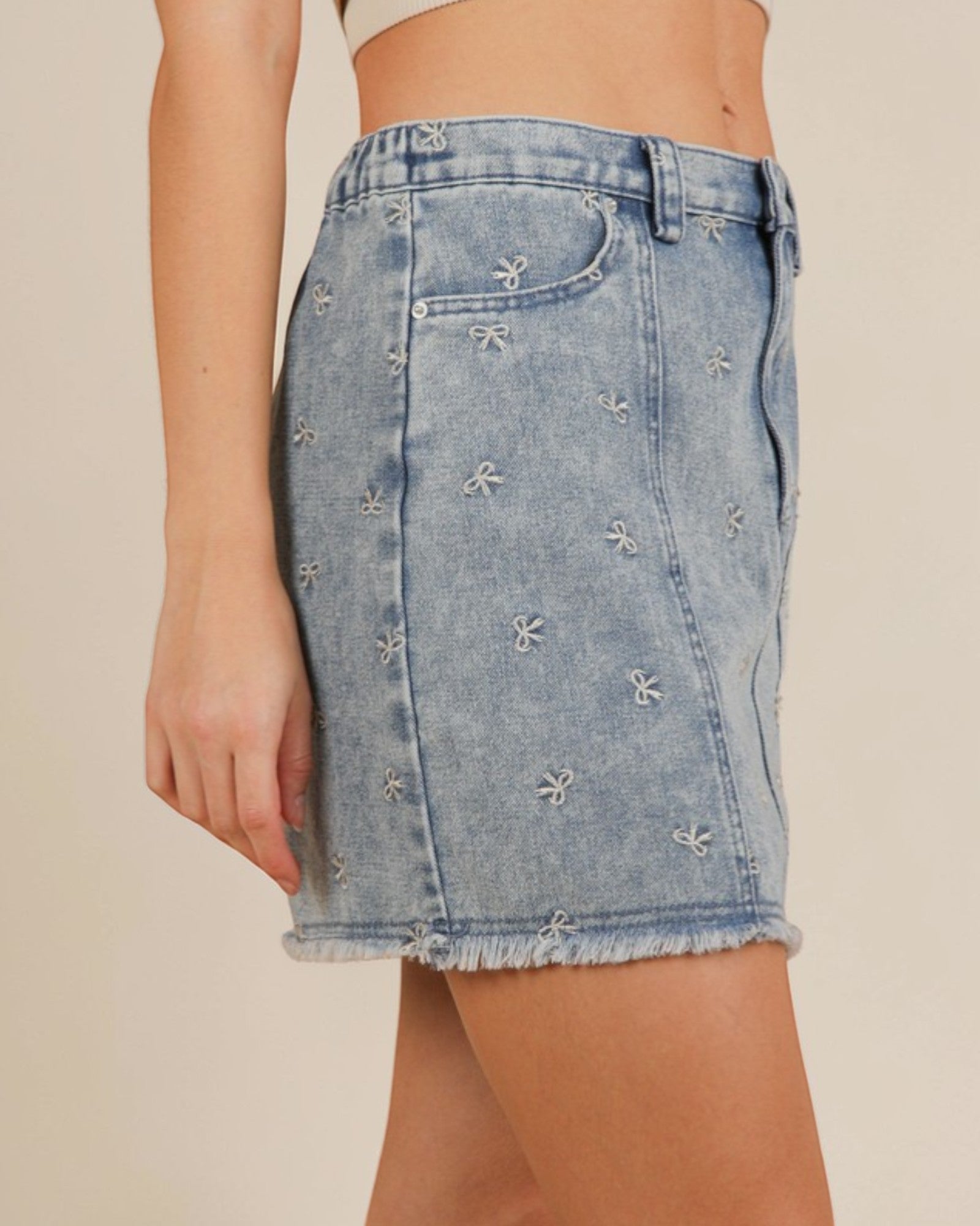 Denim skirt with floral embroidery on a beige background