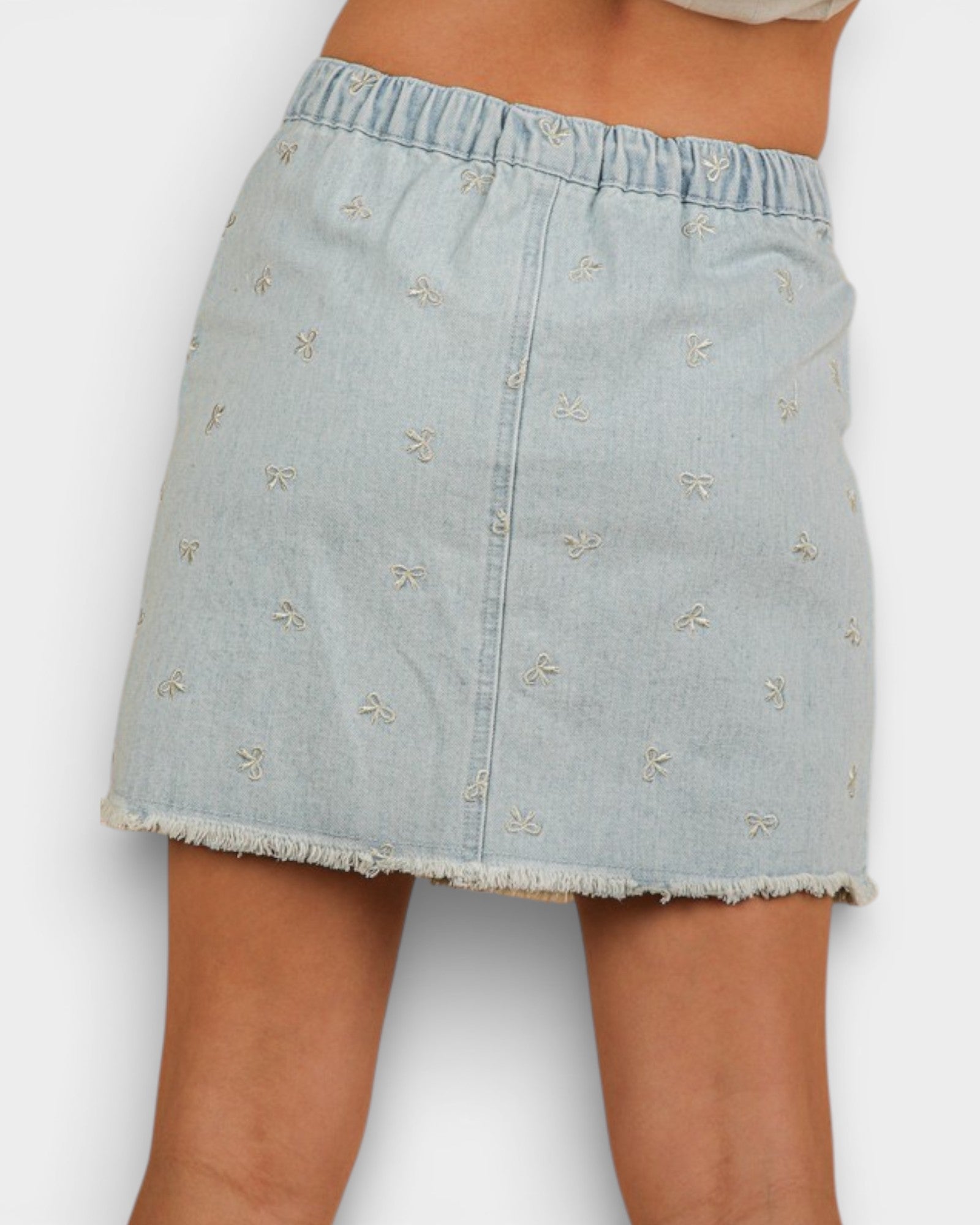Light blue denim skirt with floral embroidery on a white background