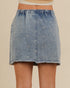 Denim skirt with bow details on a beige background