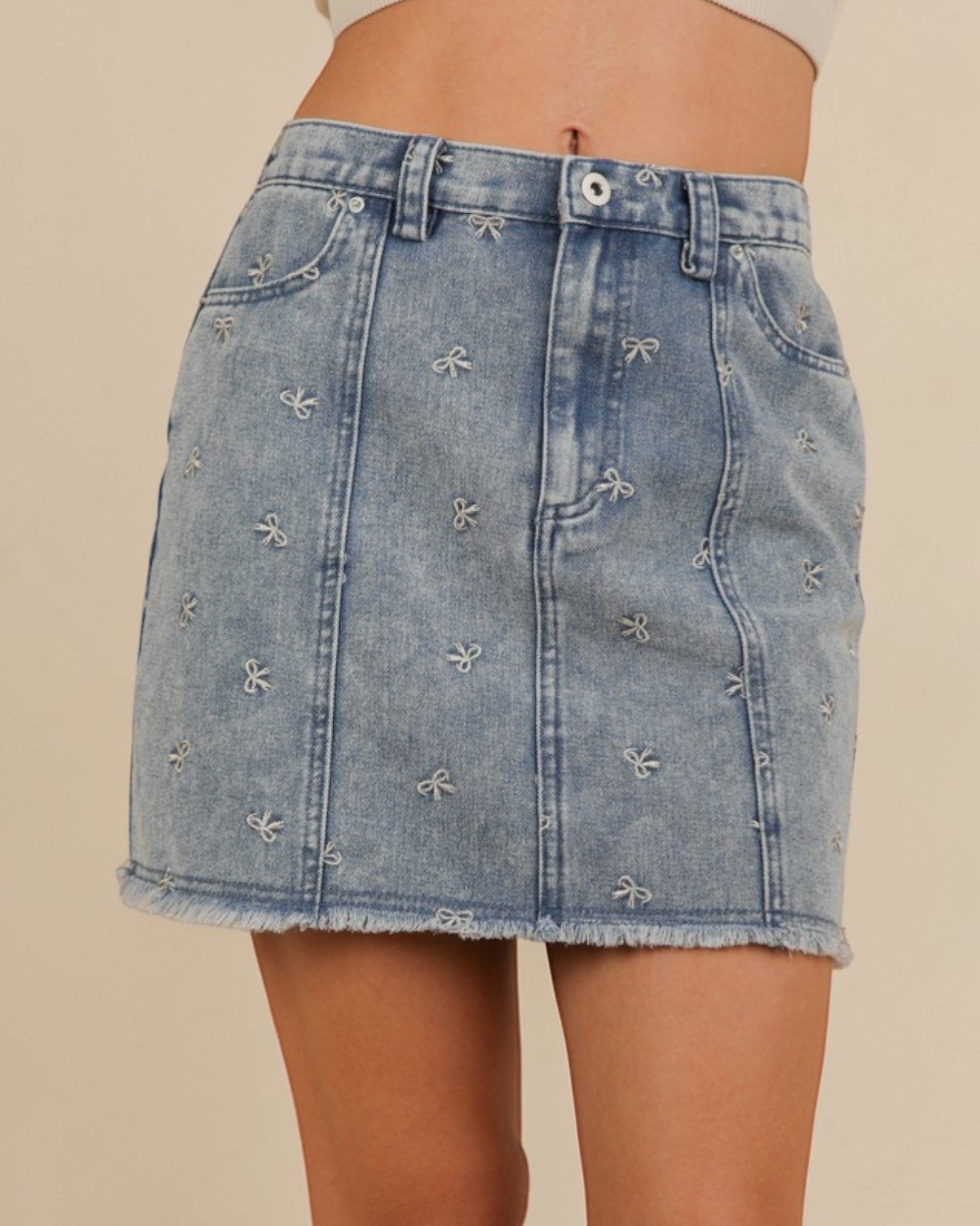 Denim skirt with floral embroidery on a beige background