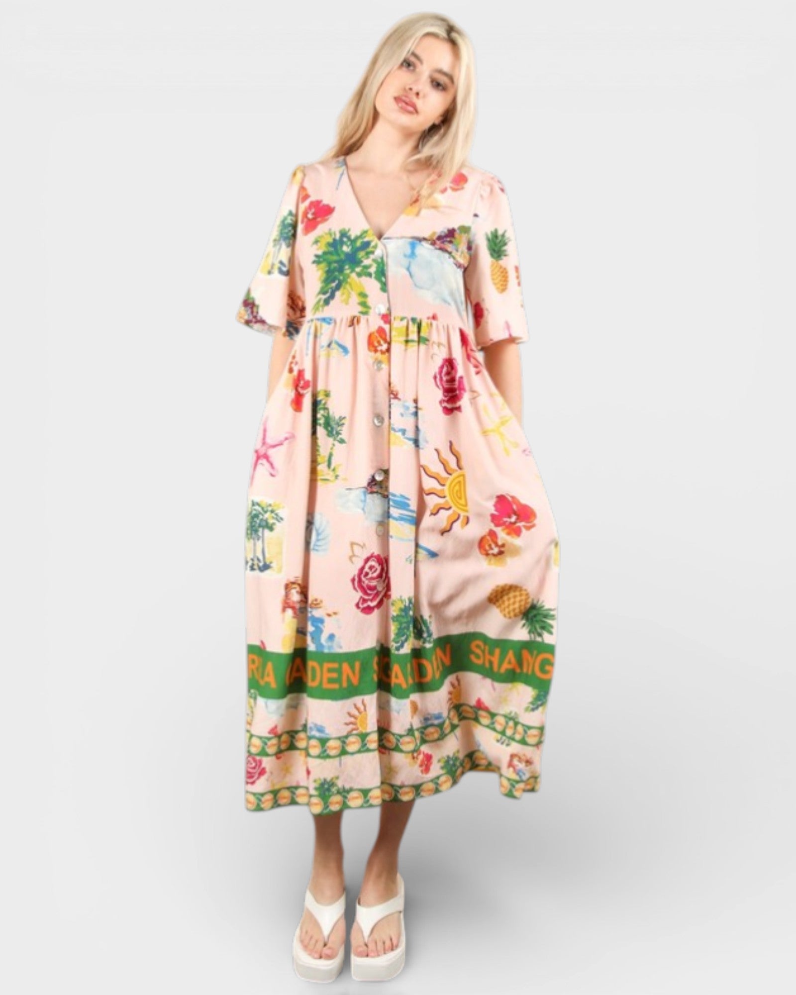 Woman wearing a colorful dress with tropical patterns on a white background