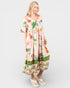 Woman wearing a colorful dress with floral patterns on a white background