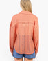 A woman shown from the back wearing a peach-colored open-knit cardigan with textured knit sleeves and collar, paired with blue denim shorts, against a plain white background.
