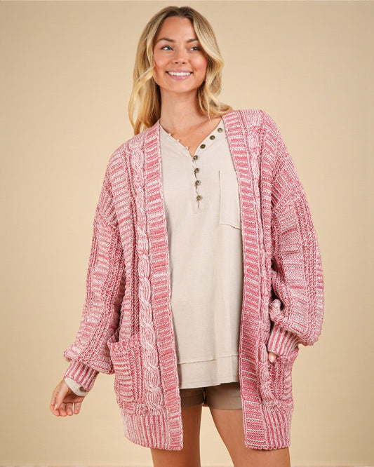Woman wearing a pink knitted cardigan on a beige background