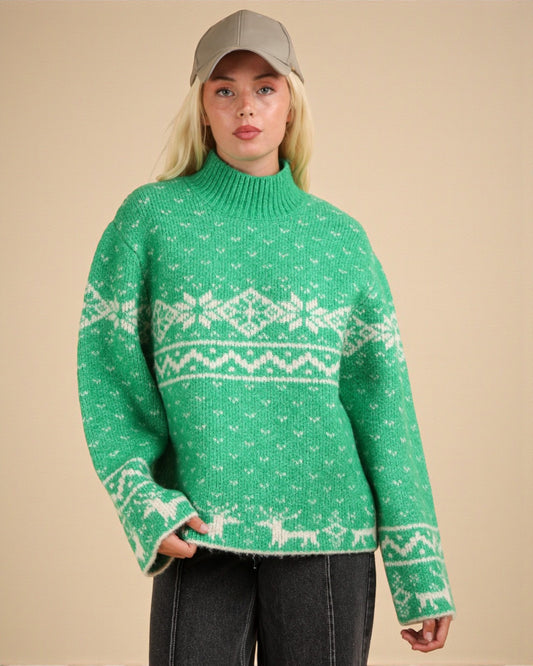 Person wearing a green sweater with white patterns on a beige background