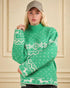 Person wearing a green sweater with white patterns against a beige wall.