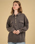 Woman wearing a brown jacket with button details on a beige background