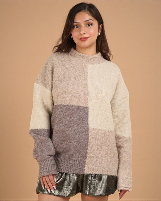 Woman wearing a patchwork sweater against a beige background