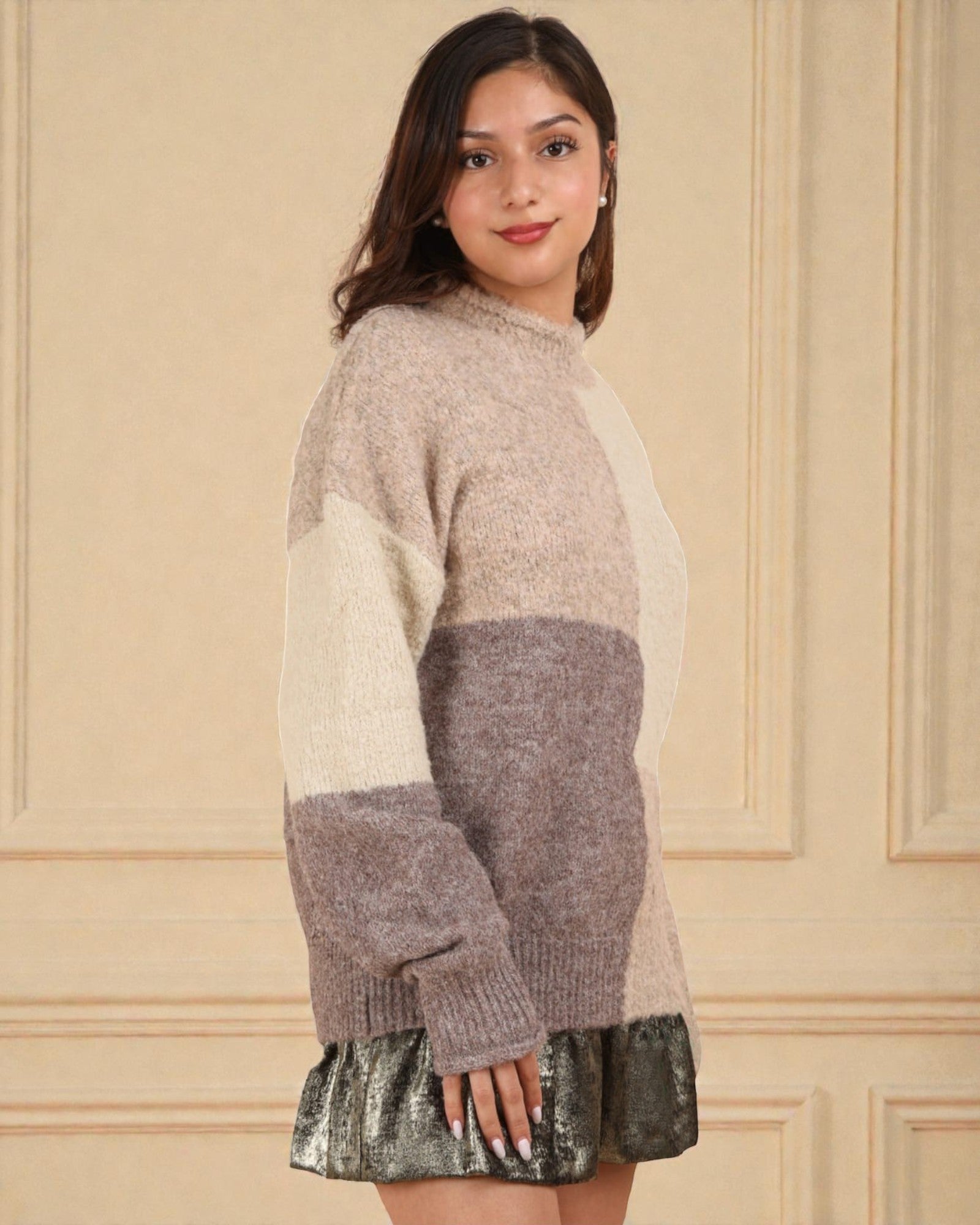 Woman wearing a color-blocked sweater with a plain background