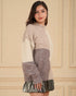 Woman wearing a color-blocked sweater with a plain background