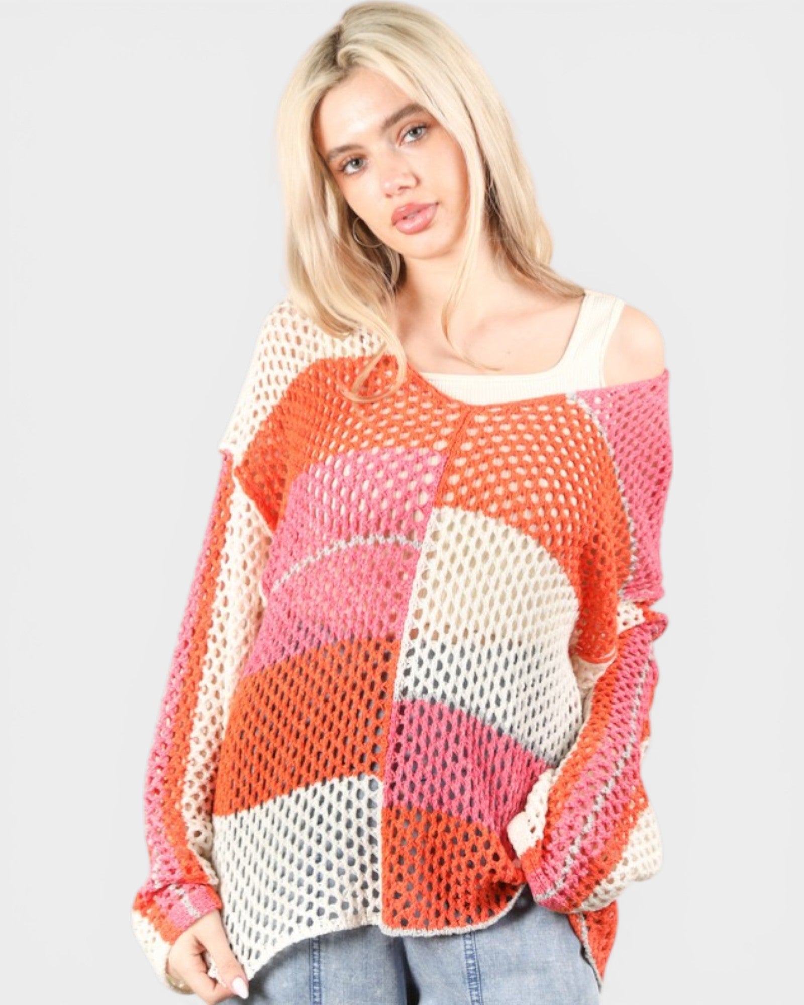 Woman wearing a colorful, patterned sweater on a plain background