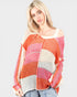 Woman wearing a colorful, patterned sweater on a plain background