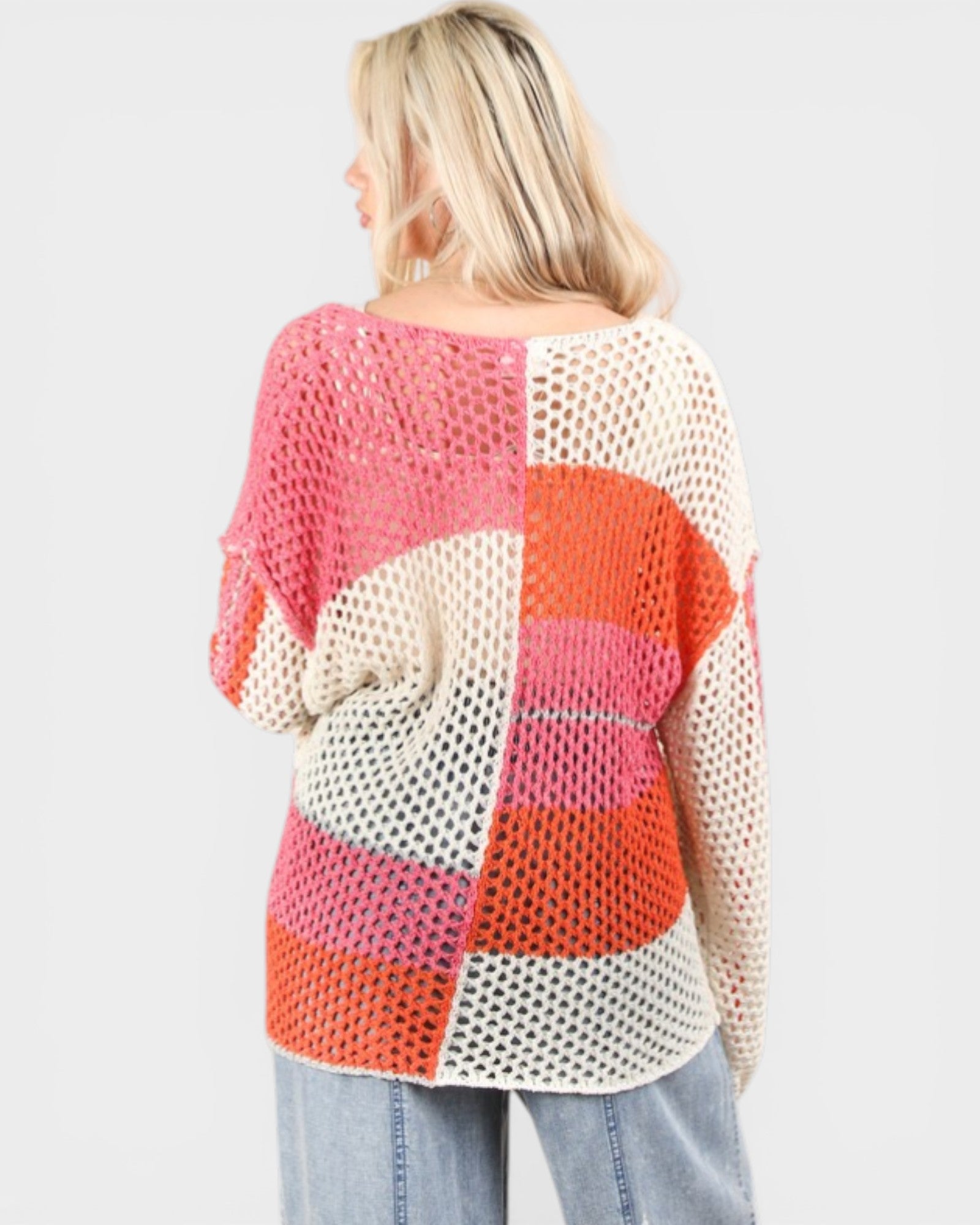 Woman wearing a colorful crochet top with a white background