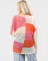 Woman wearing a colorful crochet top with a white background