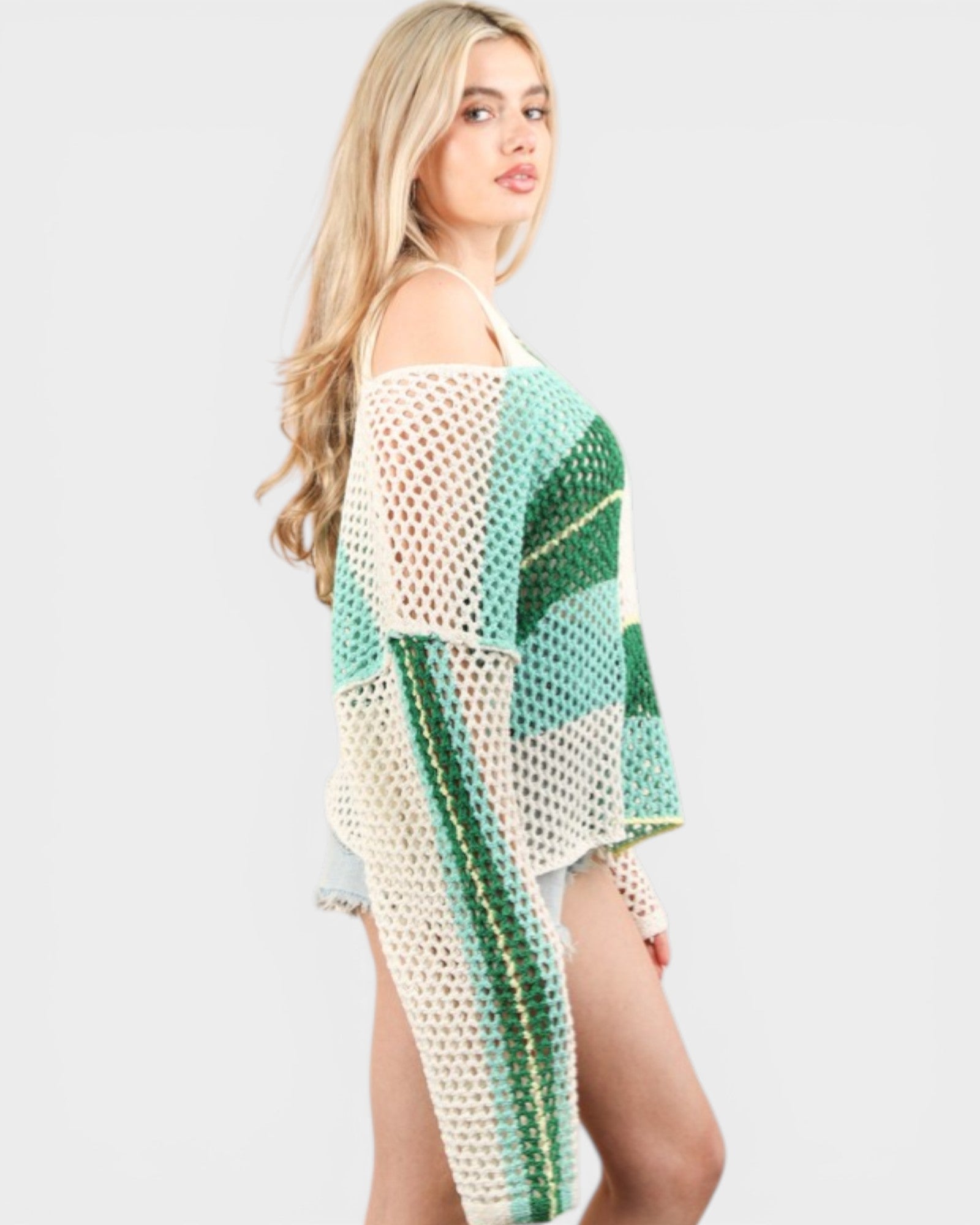Woman wearing a green and white checkered cover-up on a plain background