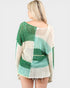 Woman wearing a green and white patterned mesh top on a light gray background