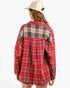 A woman shown from the back wearing a red plaid button-up shirt with a contrasting gray and black plaid yoke panel, paired with a cream baseball cap, against a plain white background.