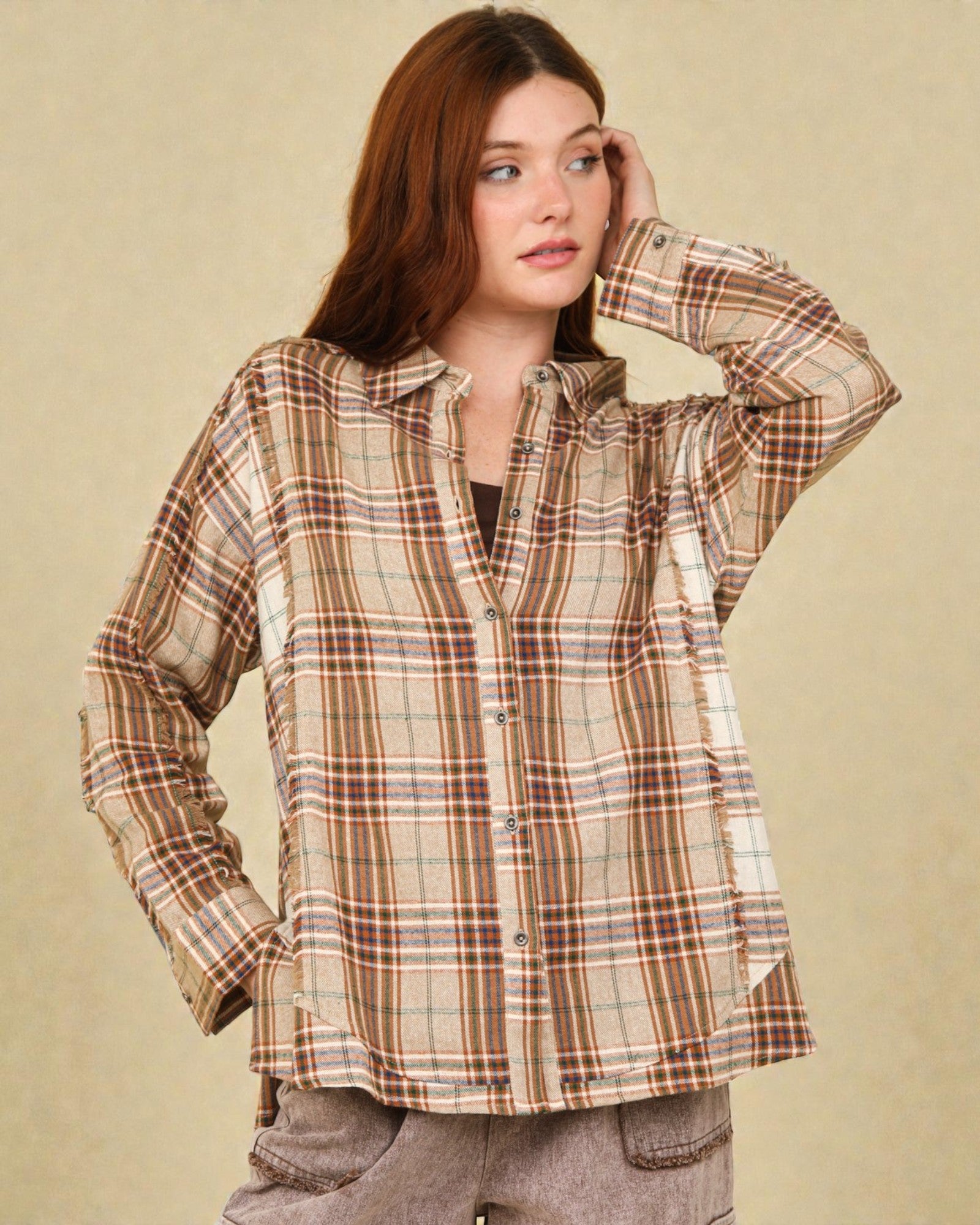 Woman wearing a plaid shirt against a beige background