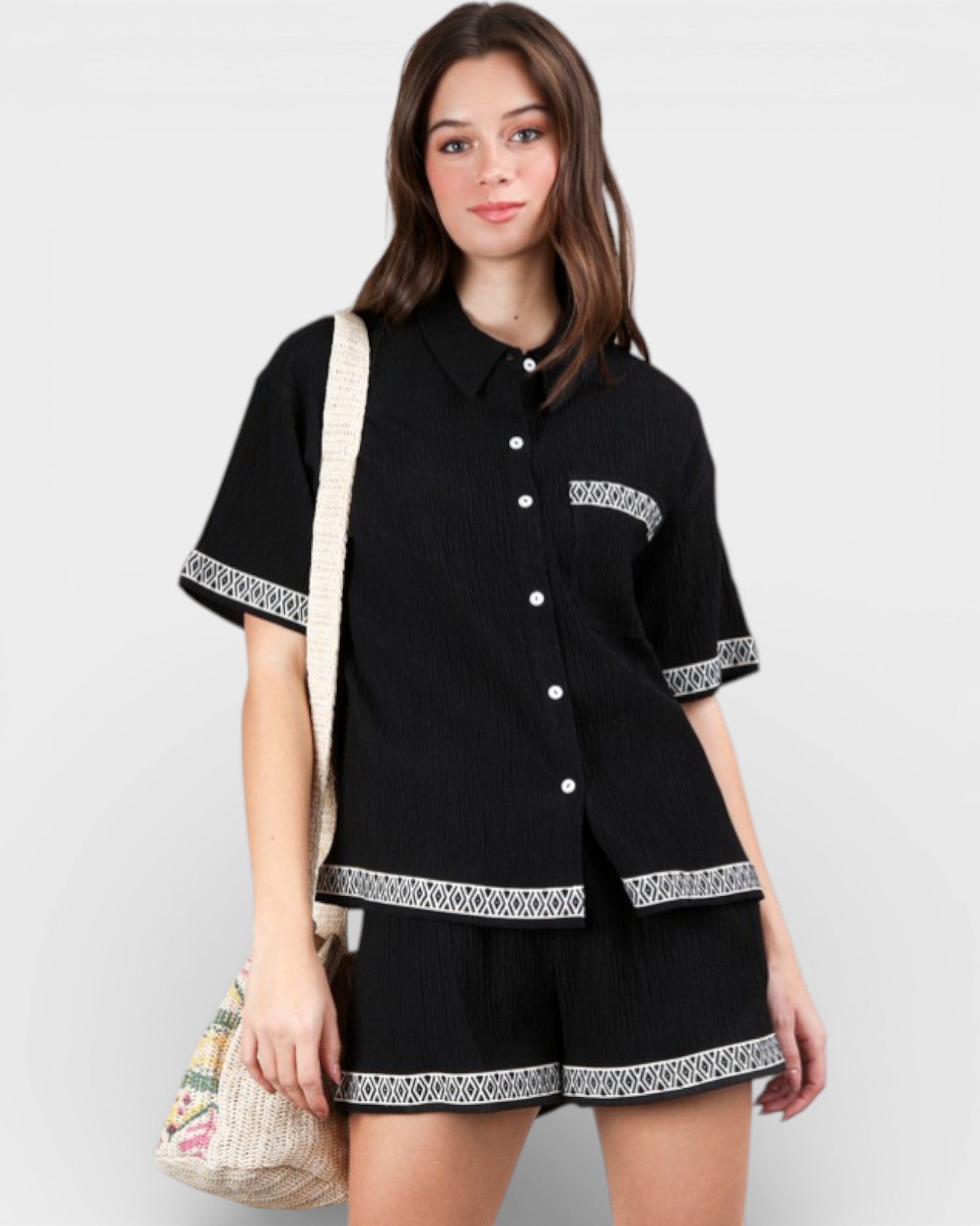 Woman wearing a black outfit with white patterns on a plain background