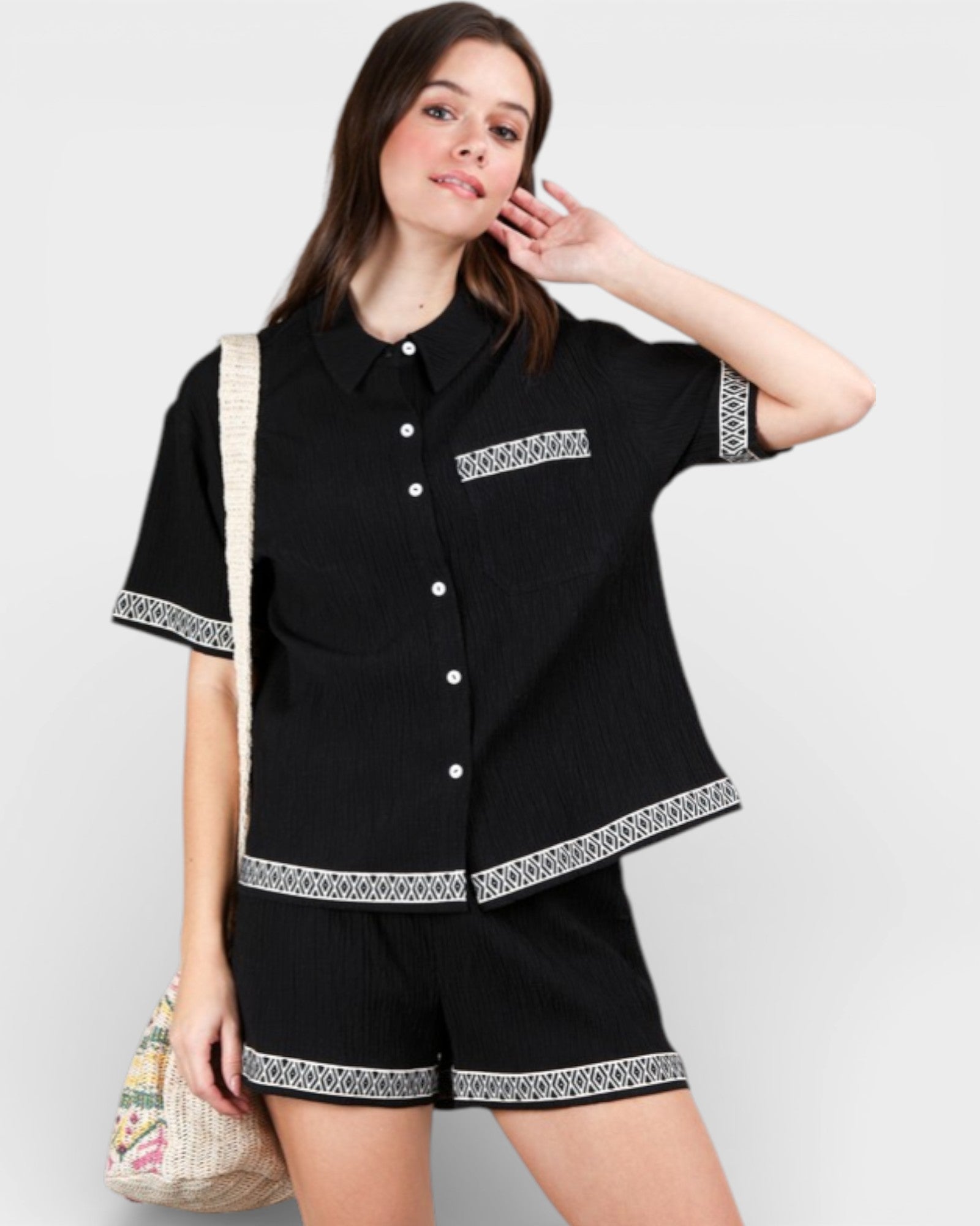 Woman wearing a black outfit with white patterns on a plain background