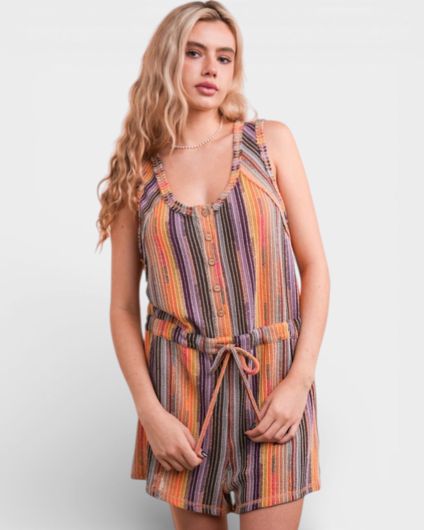 Woman wearing a colorful striped romper on a white background