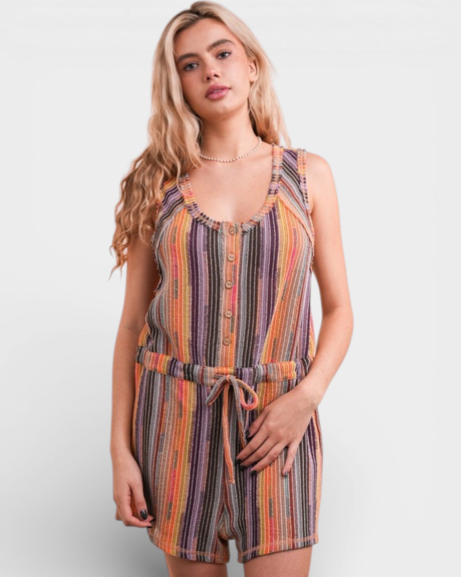 Woman wearing a colorful striped romper on a white background