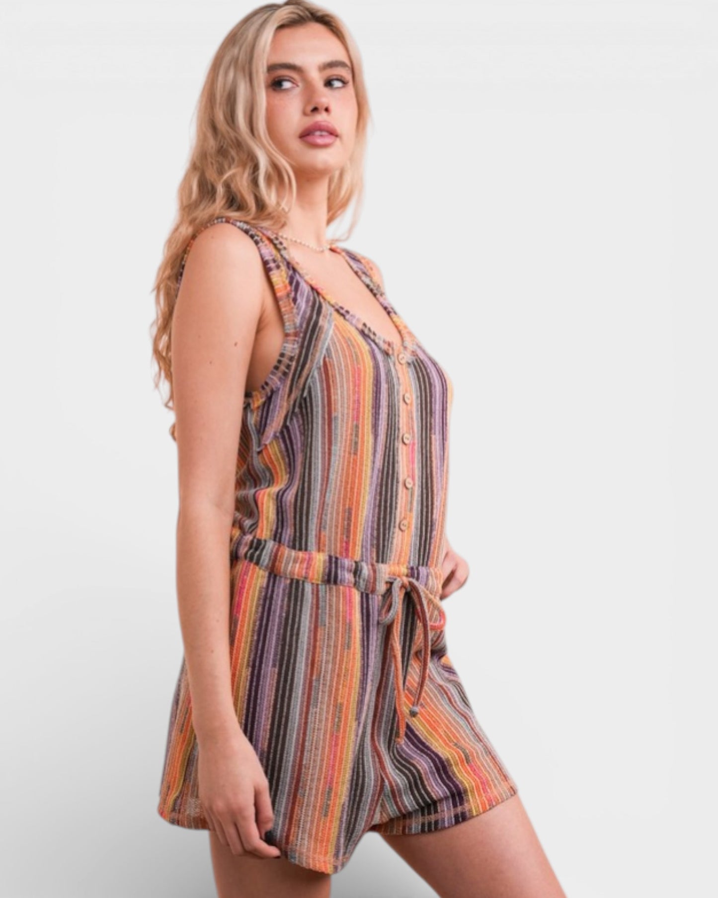 Woman wearing a colorful striped romper on a white background