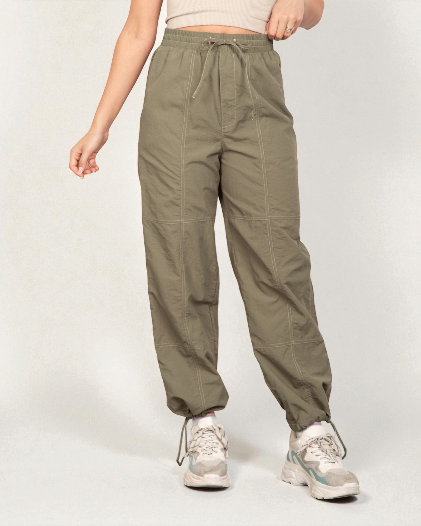 Person wearing olive green pants on a white background